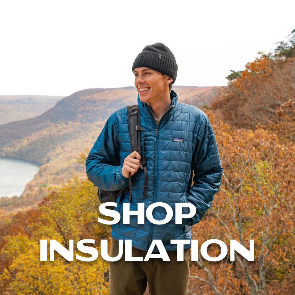 Person standing on hillside in blue insulated jacket